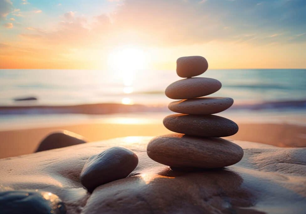 Zen stones balanced on the beach with copy space. Sunrise light. Meditation and relaxation.